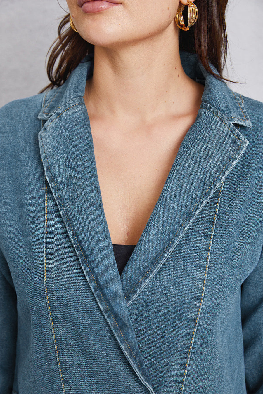 Medium wash denim blazer with tailored seam detailing and contrast stitching.