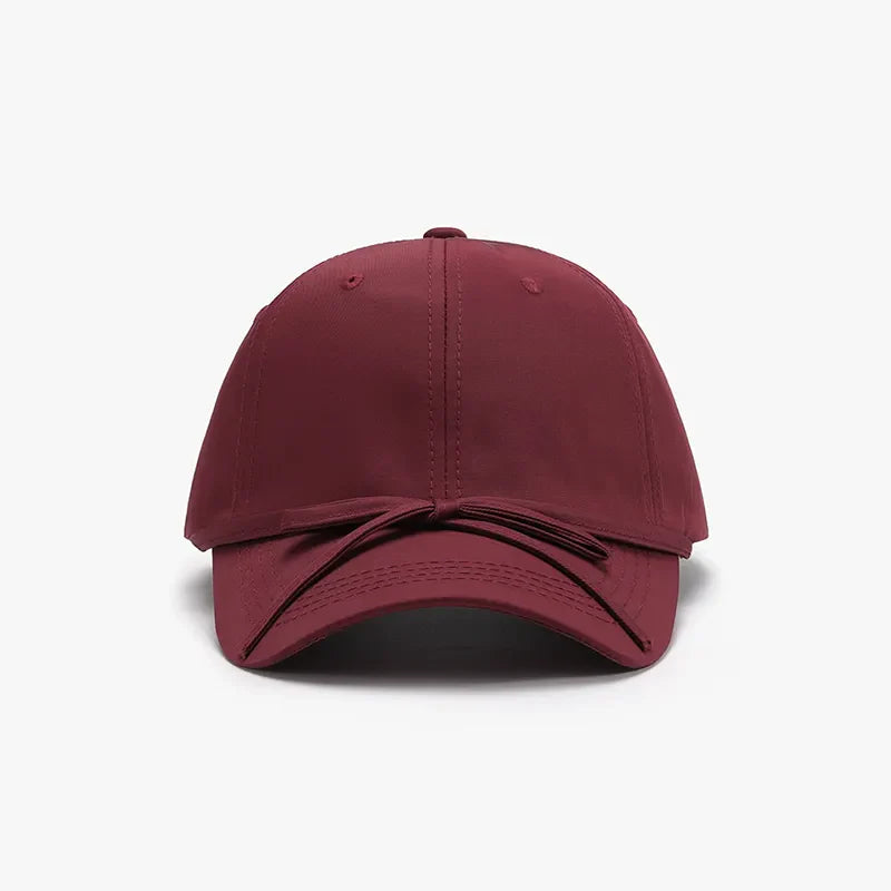 Burgundy baseball cap with a tied bow detail on the back.