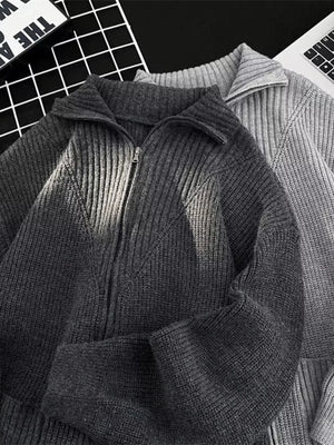 Ribbed zip-up knit cardigan in dark gray with a collared neckline and a silver zipper.