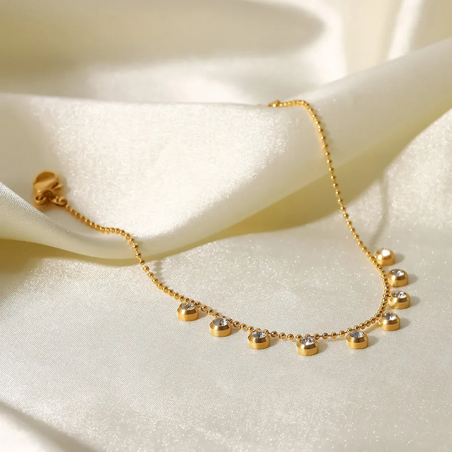 Gold-plated necklace with delicate pavé charms on a beaded chain