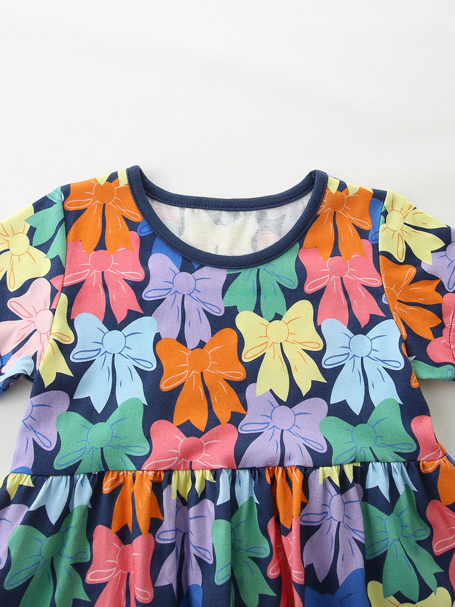 Toddler dress with colorful bow print, short sleeves, and ruffled hem.