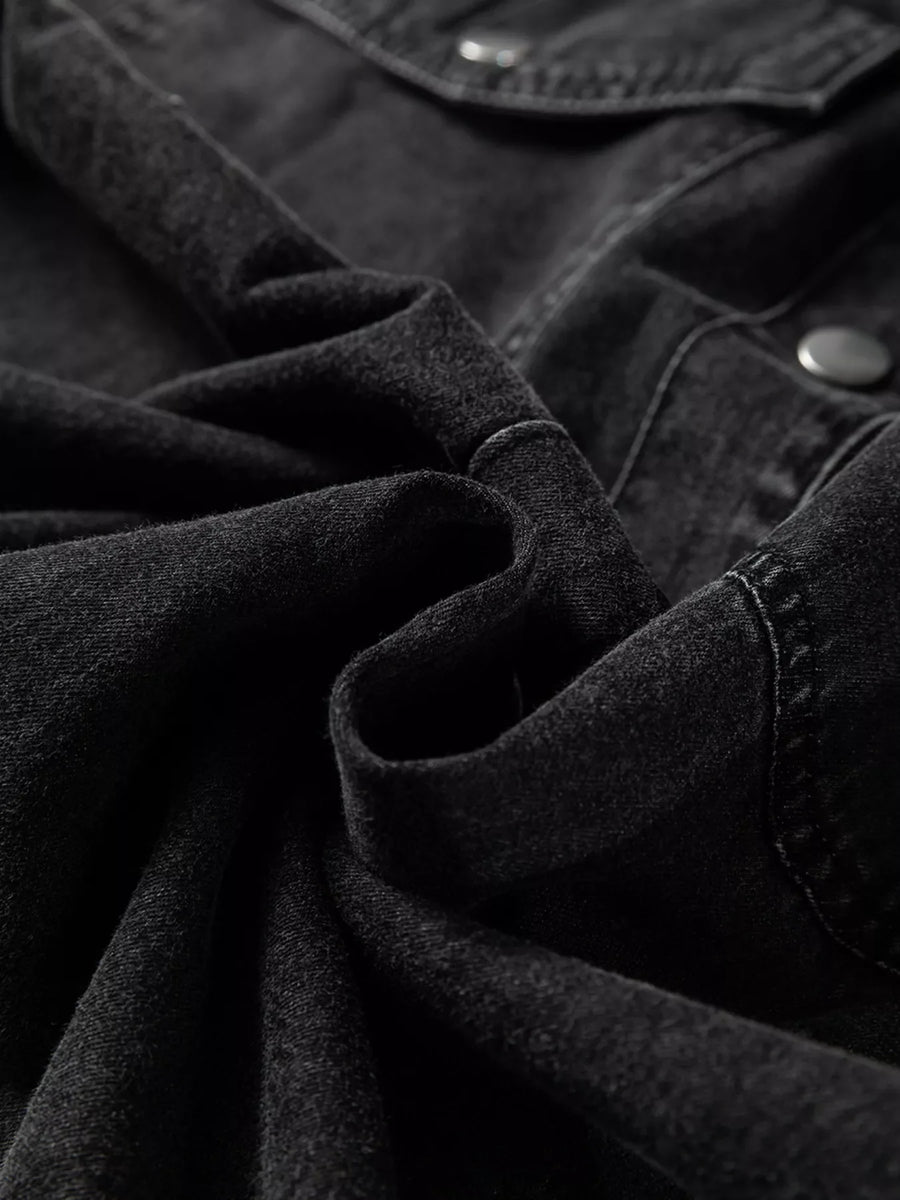 Black denim button-up dress with raw hem detail and button closure.
