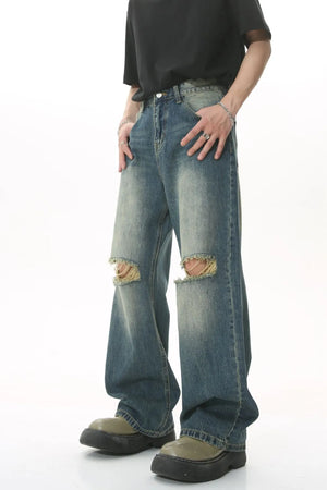 Distressed knee rip wide-leg jeans in medium wash denim with a relaxed fit.