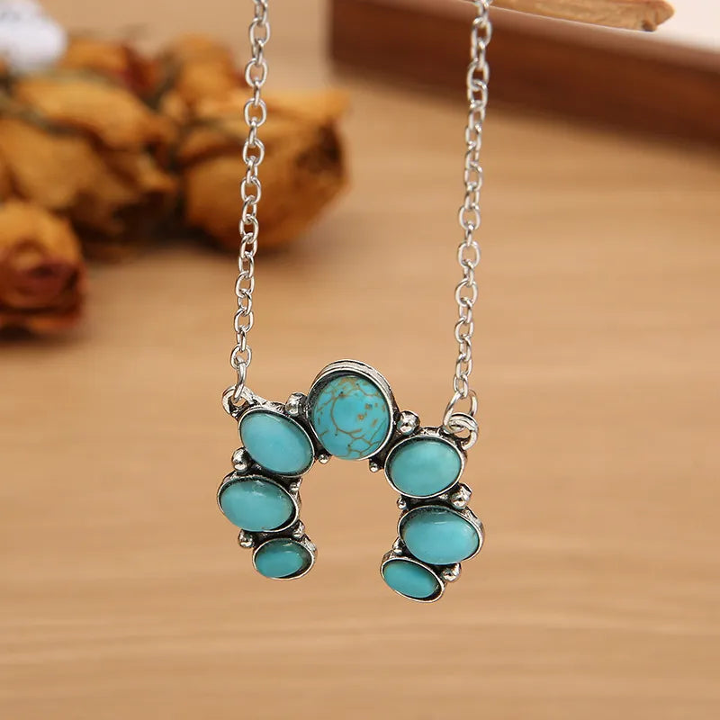 Turquoise horseshoe necklace with silver chain and alloy setting.