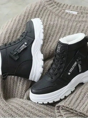 Black faux shearling platform boots with white soles and decorative zippers.
