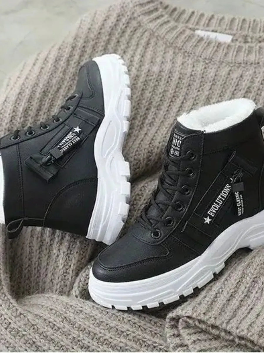 Black faux shearling platform boots with white soles and decorative zippers.
