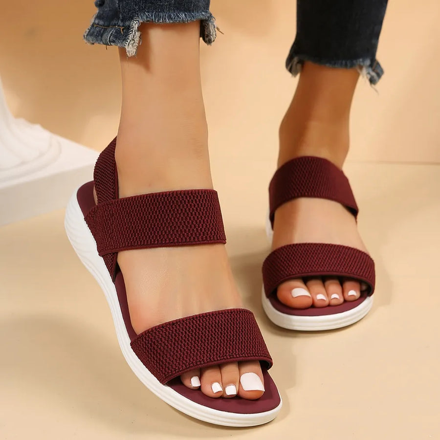 Burgundy knit strap sandals with white soles.