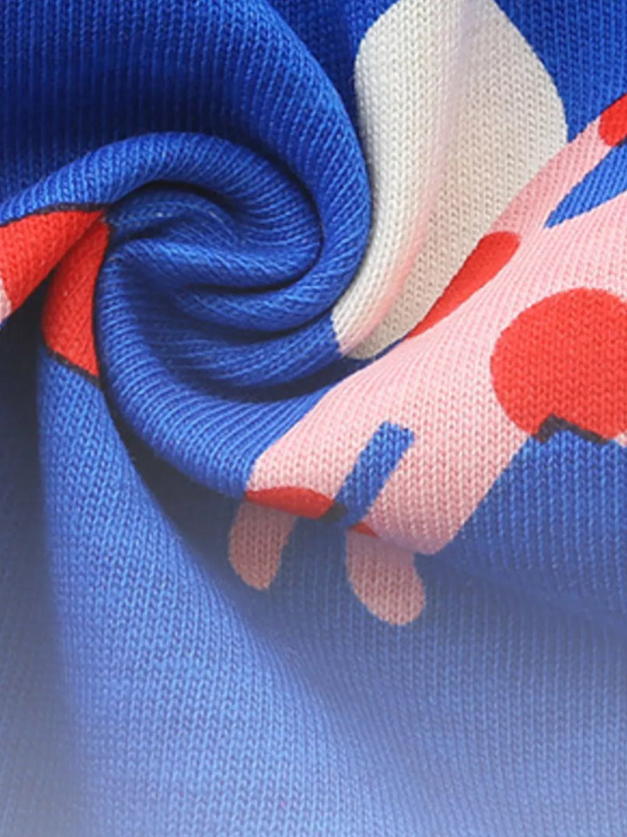 Toddler dress with blue, pink, and red polka dot pattern on cotton fabric.