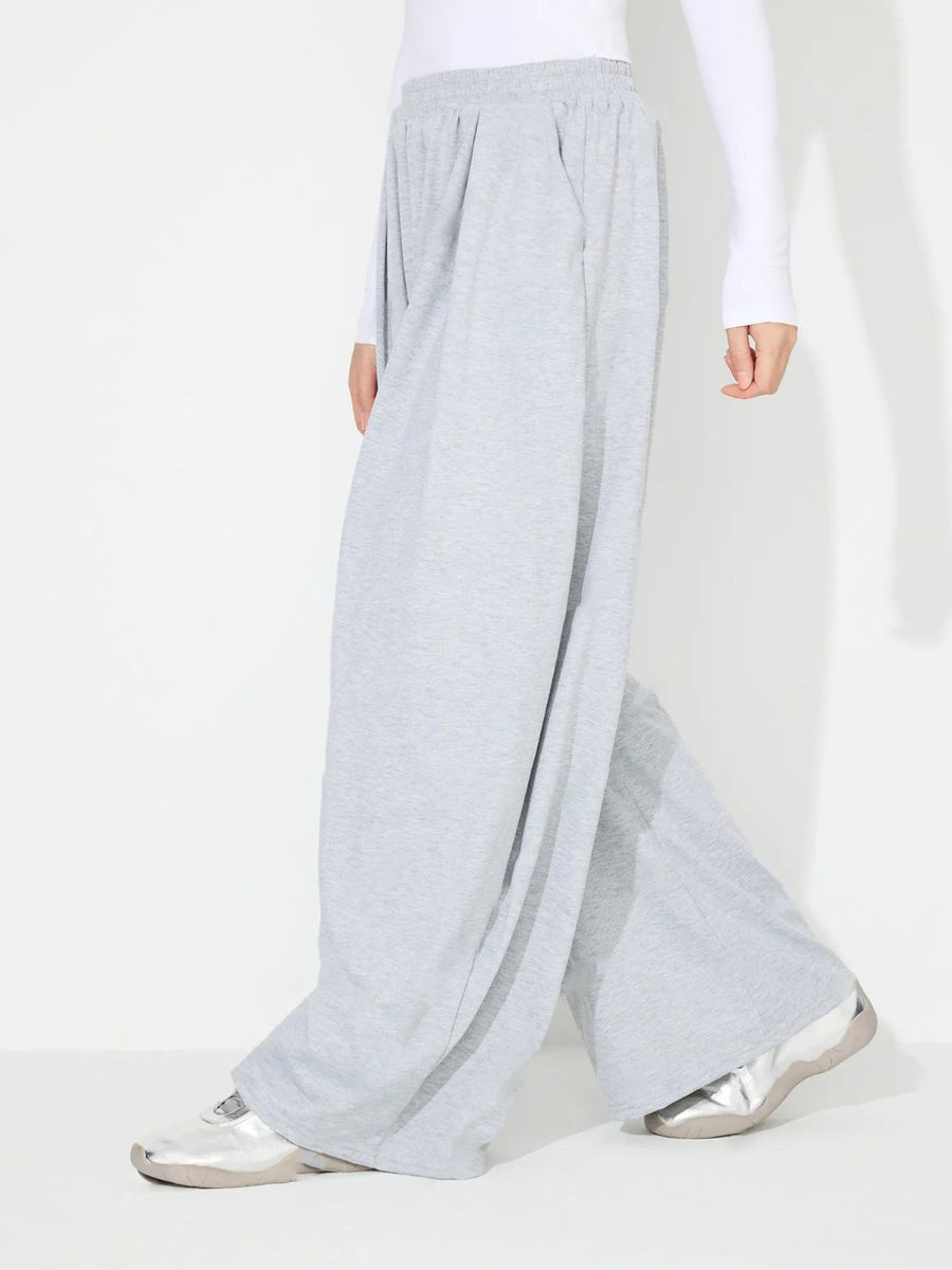 Light gray pleated drape palazzo trousers with a wide leg and elastic waistband.