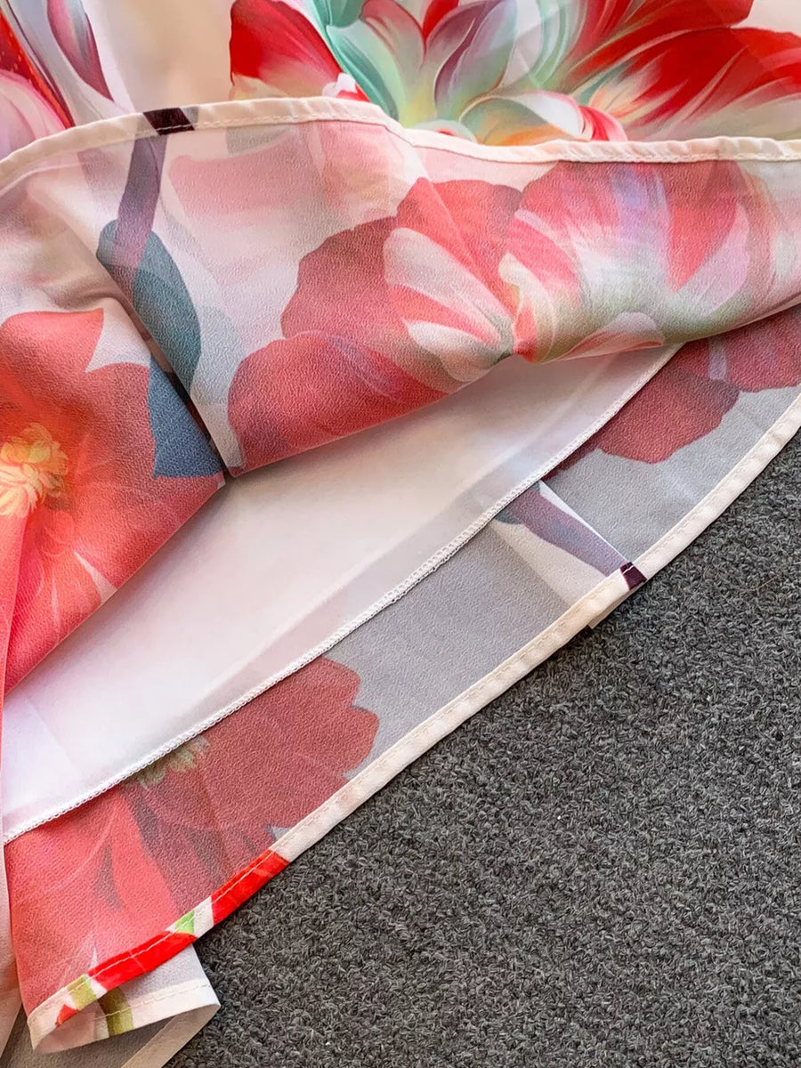 Botanical off-shoulder dress with a floral print in pink and red, showing hem detail.