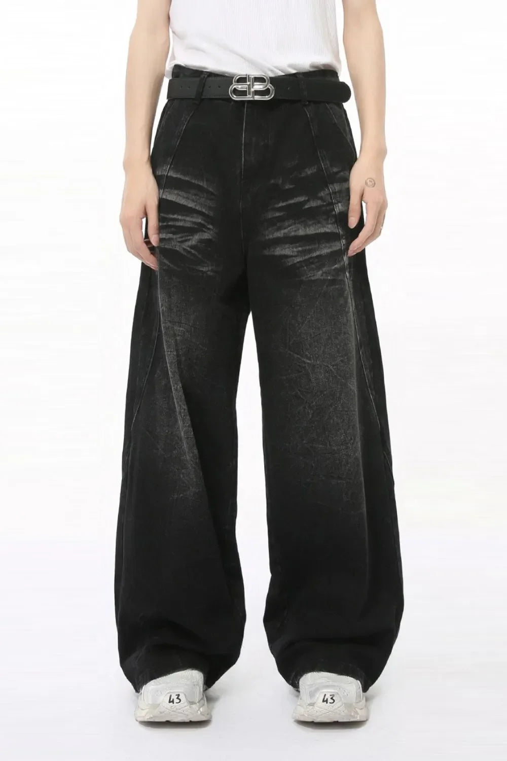 Faded black denim palazzo trousers with a wide leg and high waist, styled with a belt.