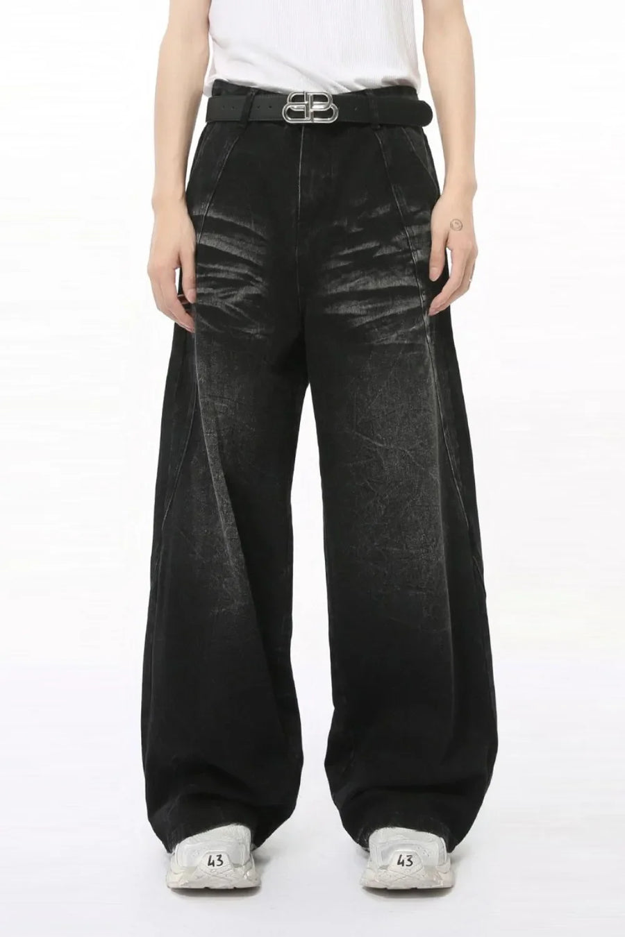 Faded black denim palazzo trousers with a wide leg and high waist, styled with a belt.