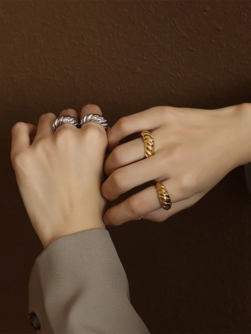 Sculpted steel croissant rings in silver and gold, featuring a twisted band design.