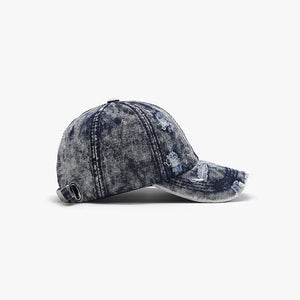 Distressed acid wash denim baseball cap with frayed details and adjustable strap.