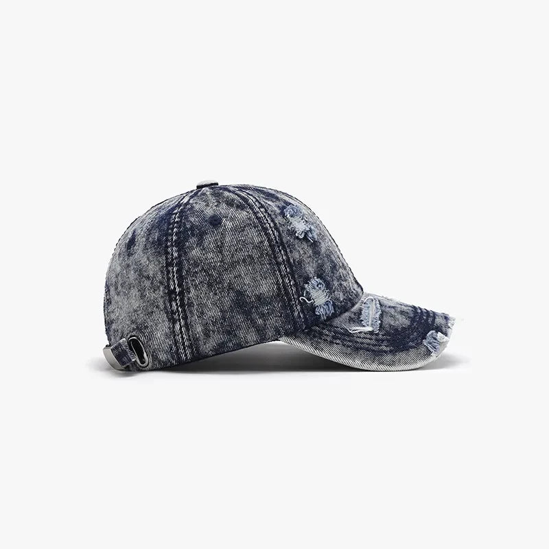 Distressed acid wash denim baseball cap with frayed details and adjustable strap.