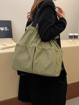 Green drawstring backpack with front pockets and adjustable straps.