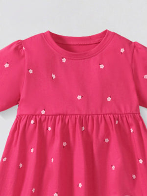 Toddler pink cotton dress with scattered white flower applique and puff sleeves.