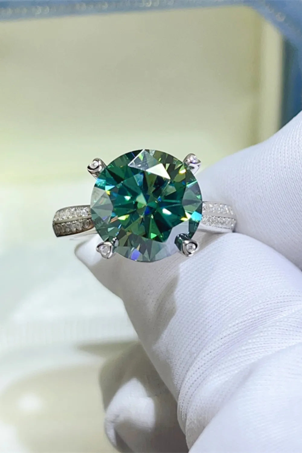 Dark green moissanite solitaire ring with a detailed silver band.