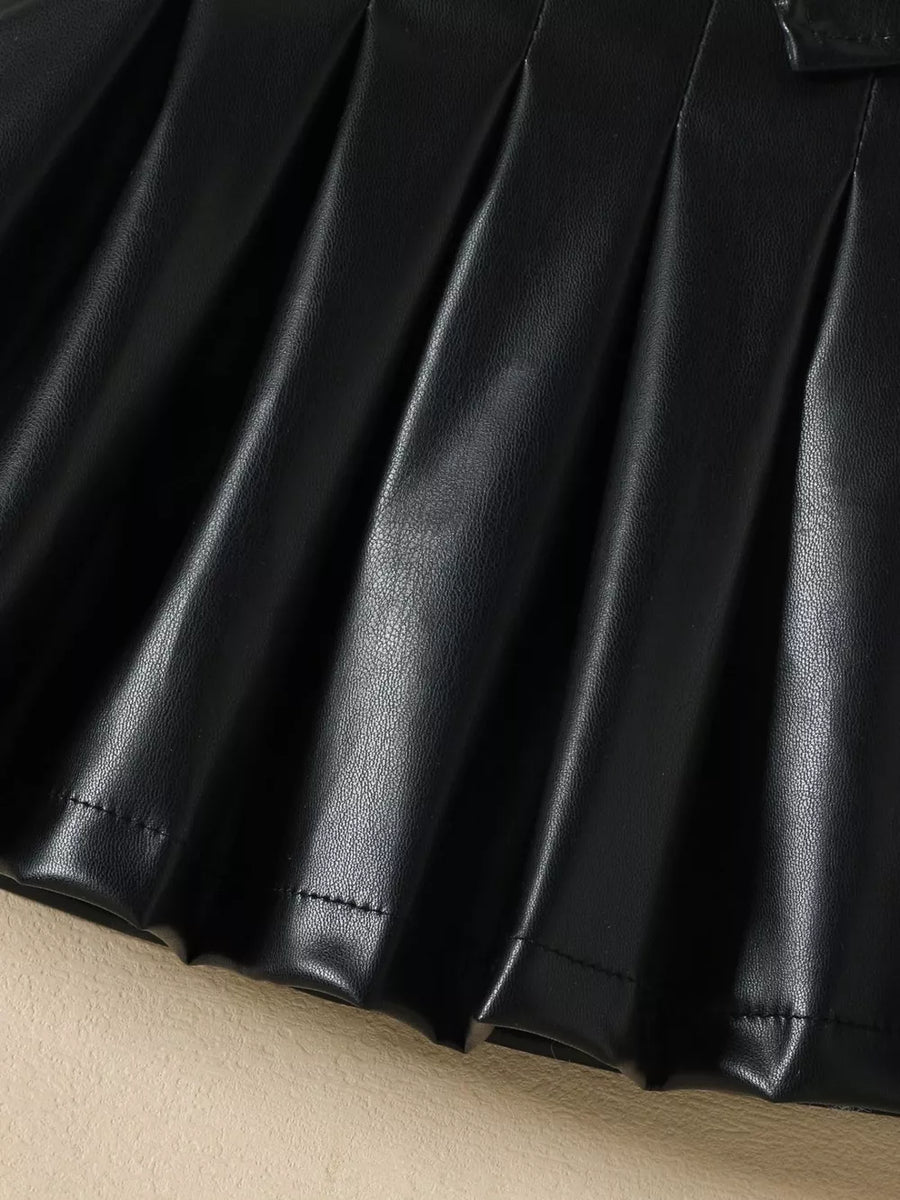 Black faux leather baby skirt with pleats and stitched hem detail.
