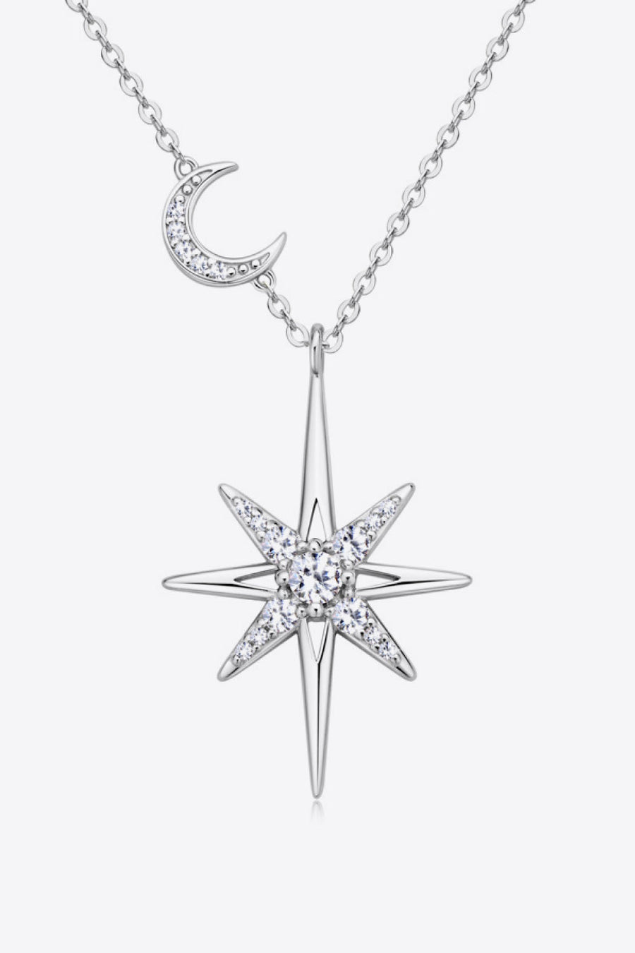 Silver celestial starburst pendant necklace with crescent moon charm, adorned with clear crystals.