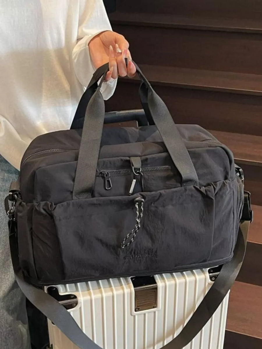 Black travel duffel bag with multiple zippered pockets and adjustable strap.
