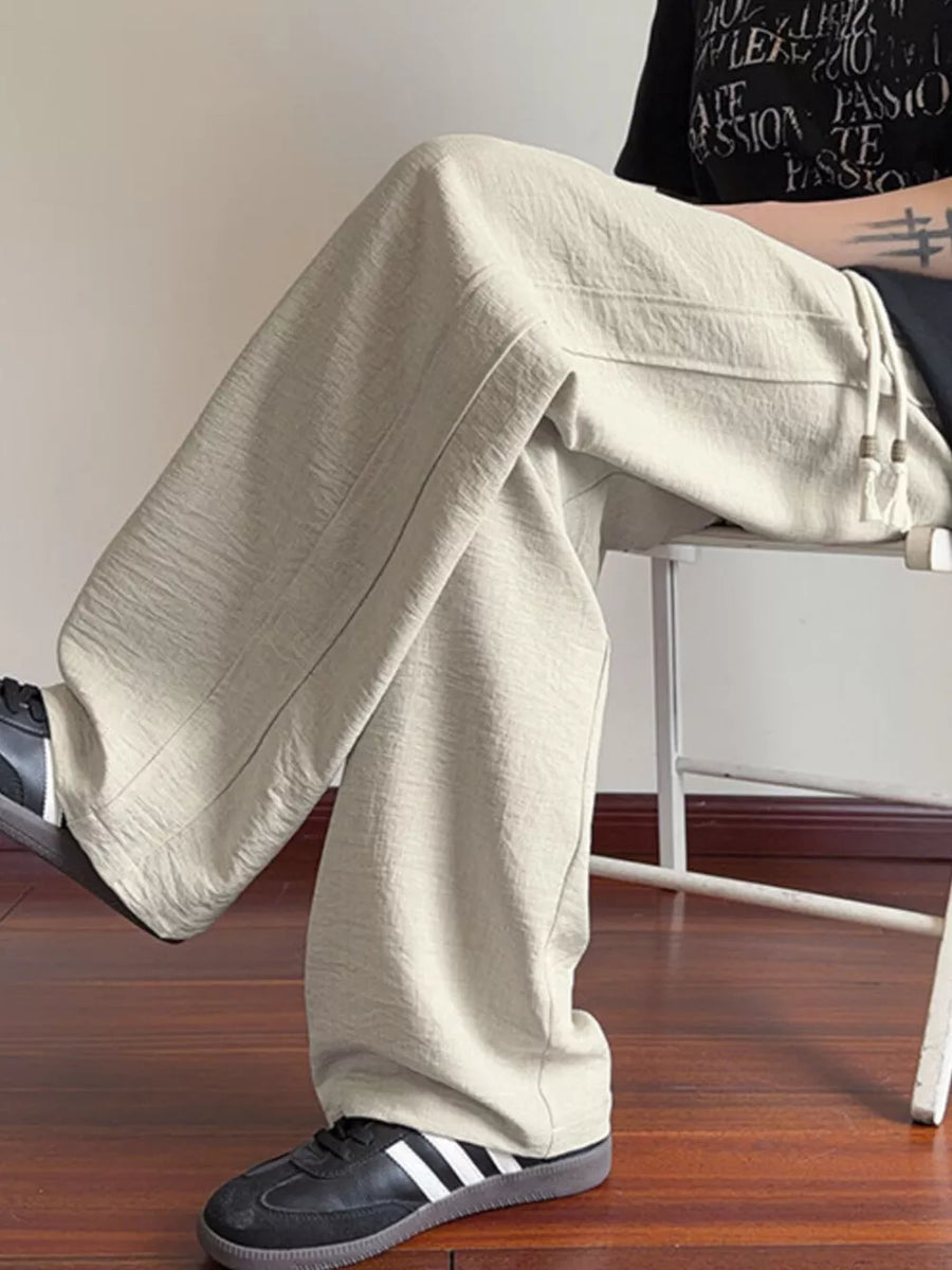 Cream wide-leg drawstring sweatpants with textured fabric and relaxed fit.