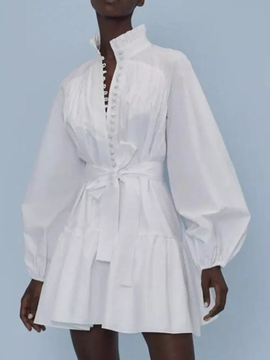 White cotton dress with ruffled collar, button front, tie waist, and tiered skirt.