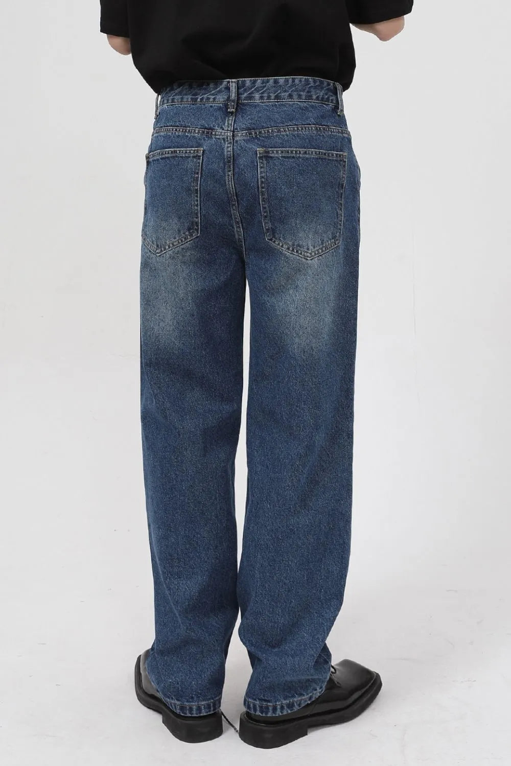 Zip-front relaxed fit denim jeans in medium wash with a baggy cut.