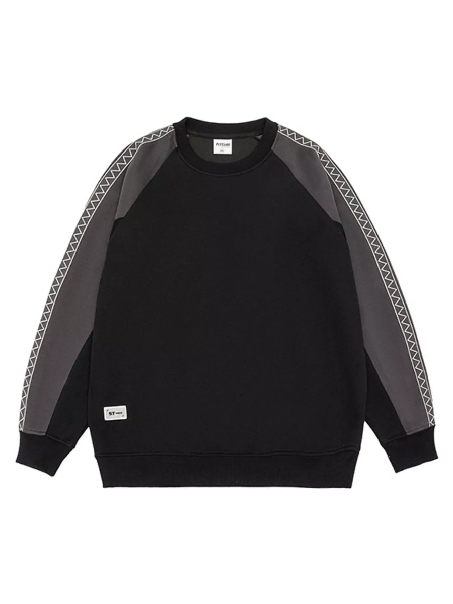 Black oversized raglan sleeve sweatshirt with contrast gray sleeves featuring zigzag stitching detail.