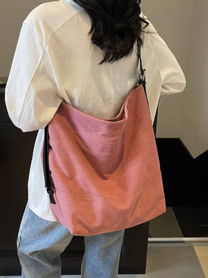 Pink hobo bag with adjustable strap worn over the shoulder.