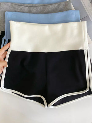 Black athletic shorts with white contrast trim and a white high-rise waistband.