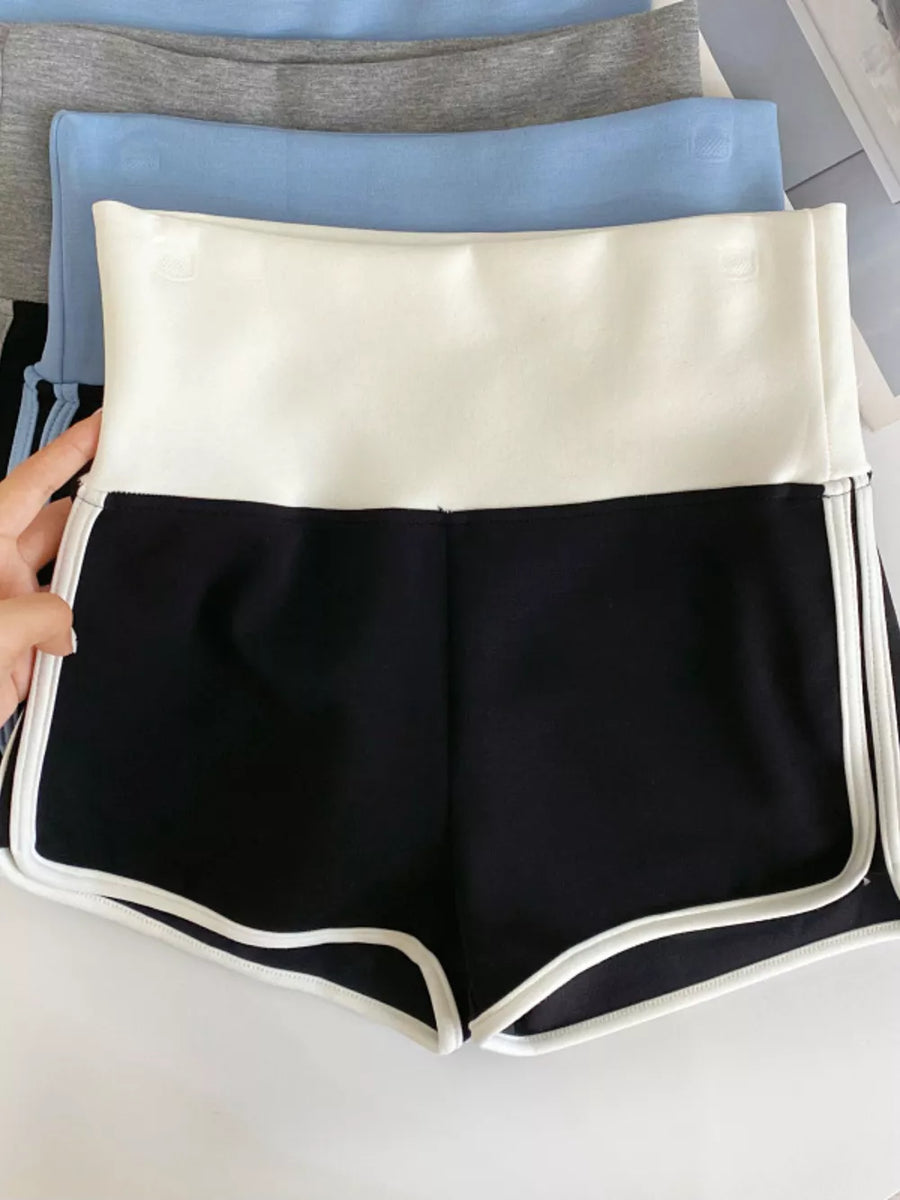 Black athletic shorts with white contrast trim and a white high-rise waistband.