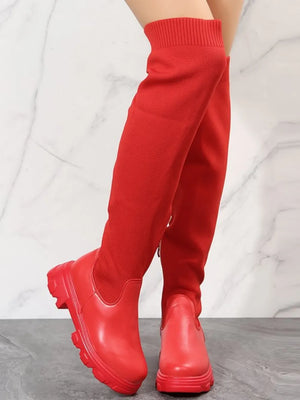 Red knit-top platform over-the-knee boots with a chunky sole.