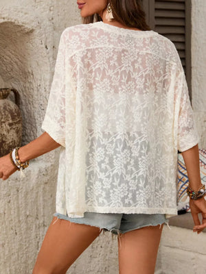 White floral lace sheer top with lace trim and short sleeves.