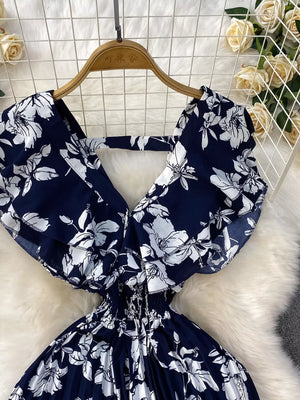 Dark blue floral print romper with smocked waist and flutter sleeves.