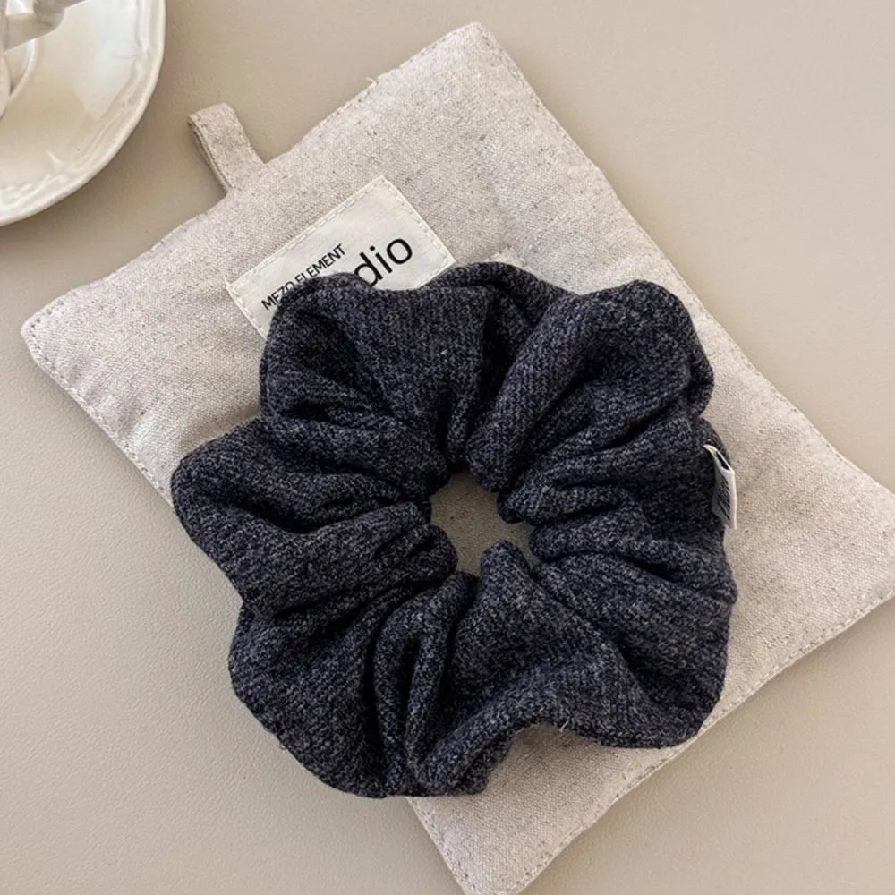 Textured knit scrunchie in dark gray, part of a 3-piece set.