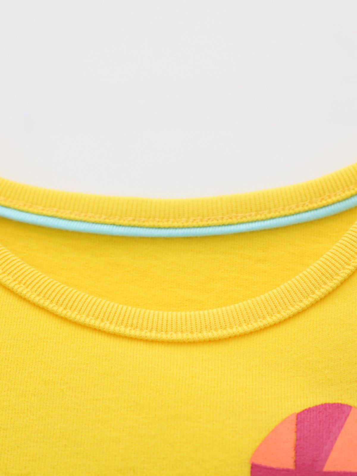 Yellow cotton crew neck t-shirt with blue trim and graphic detail