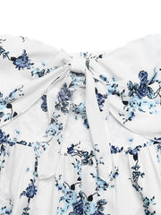 White floral romper with blue flowers, smocked back and tie-front detail.