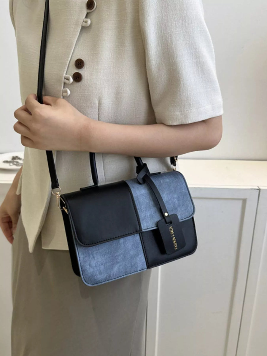 Chic two-tone PU leather crossbody bag with black and denim blue panels.
