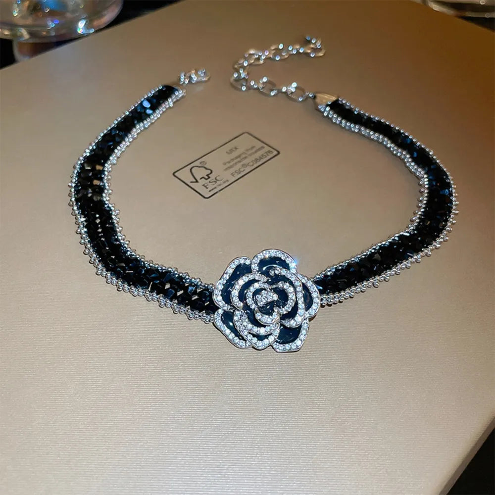 Black crystal choker necklace with a silver-tone rose pendant and chain.