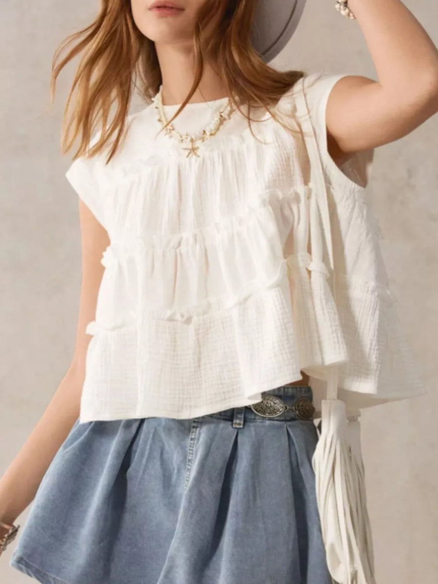 Relaxed tiered ruffle blouse in white with short sleeves and a textured fabric.