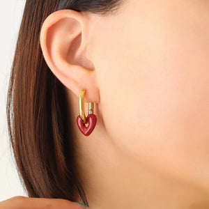 Gold hoop earrings with a crimson heart charm