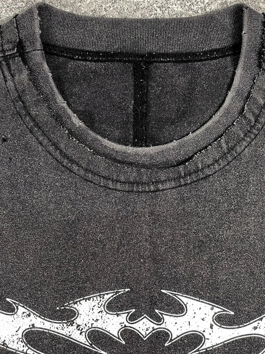 Black distressed graphic tee with distressed neckline and white graphic detail.