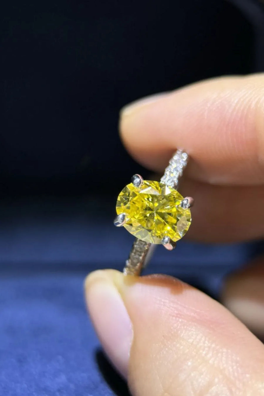 Radiant yellow oval moissanite ring with diamond-accented band.