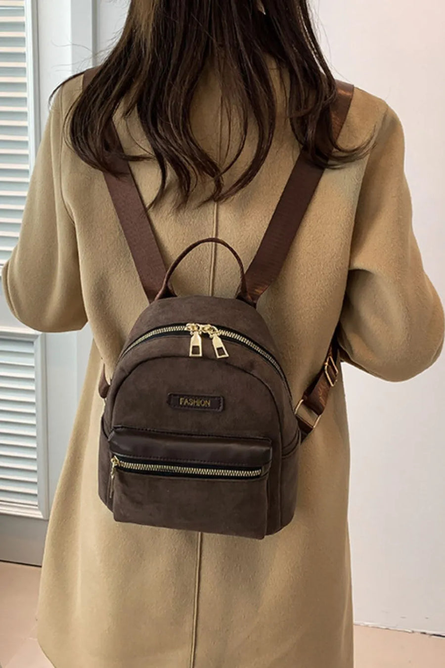 Coffee brown suede mini backpack with golden zips and front pocket.
