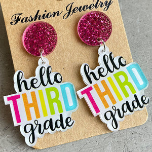 Acrylic drop earrings with pink glitter tops and "hello THIRD grade" text