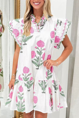 White mini dress with pink floral print, ruffled sleeves, and green scalloped trim.