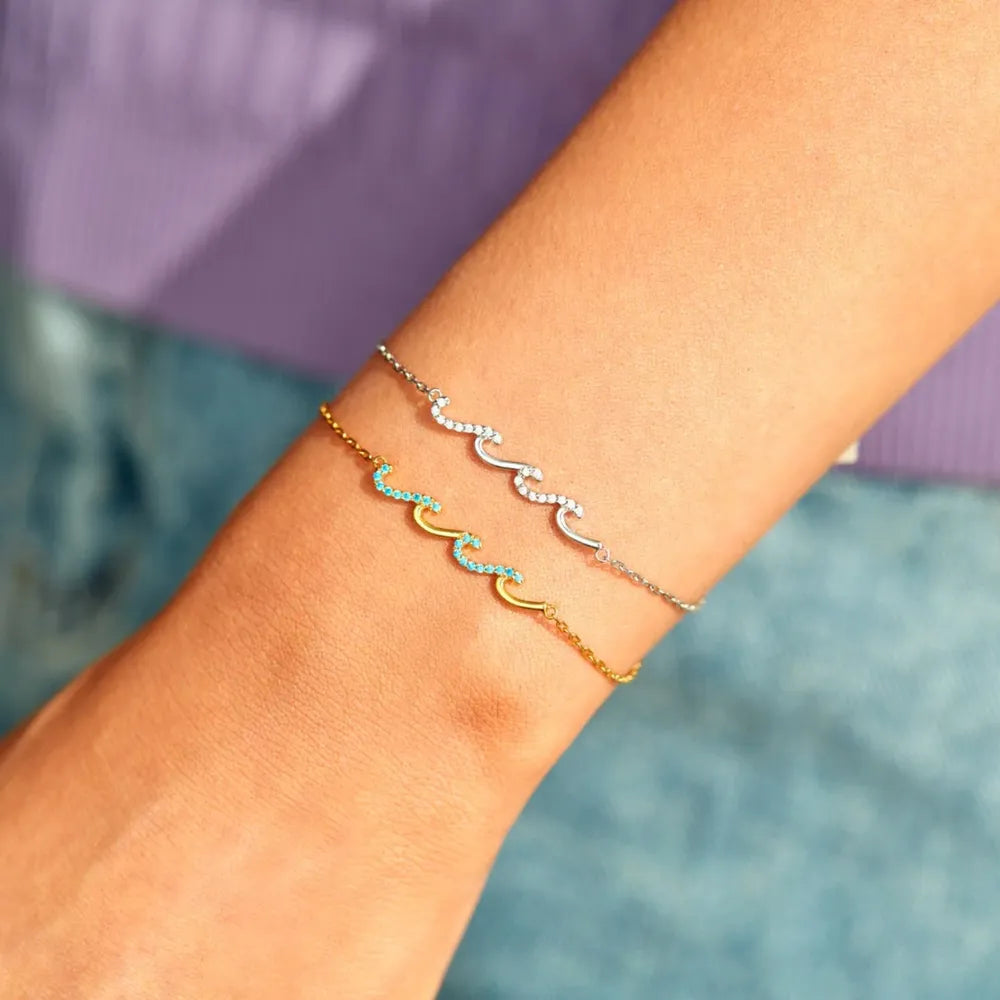 Ocean Wave Zirconia Bracelet in gold with turquoise stones and silver with white stones.