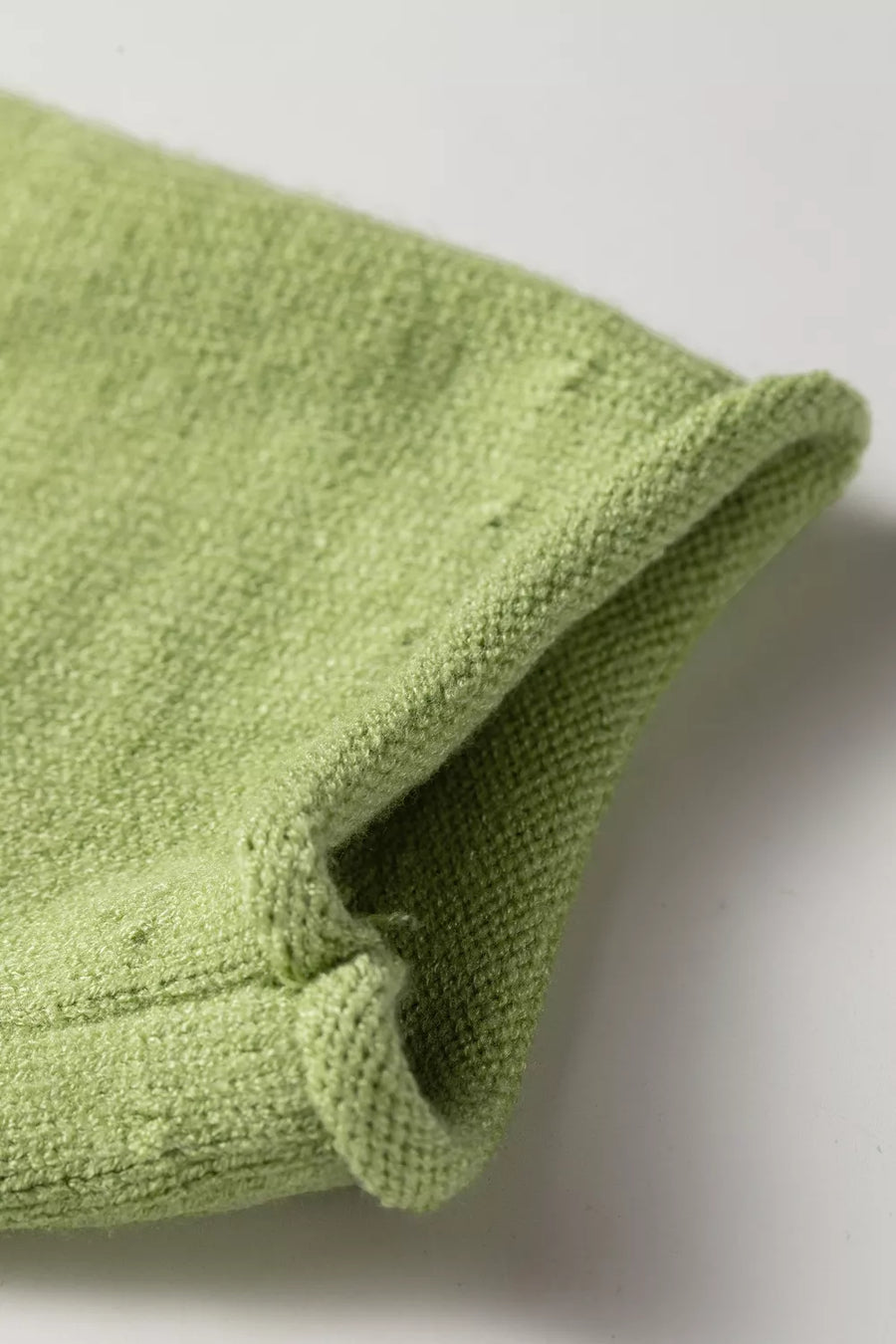 Light green textured knit sweater with rolled cuff detail