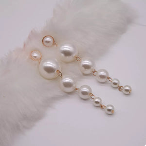 Gold cascading pearl drop earrings with varying pearl sizes.